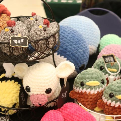 Table with display of crochet ducks, cows, chickens, bees.